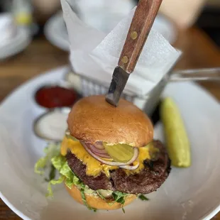 a burger with a knife stuck in it