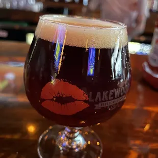 a glass of beer with a red lip on it