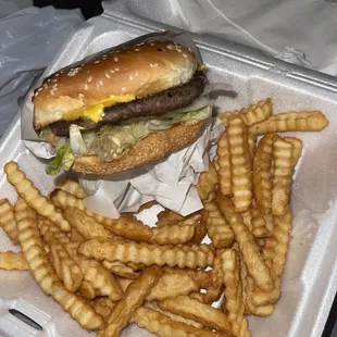a hamburger and fries in a styrofoam container
