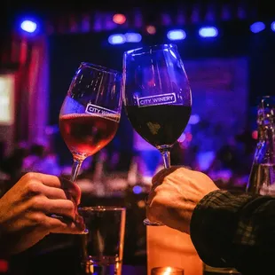 two people toasting with wine glasses