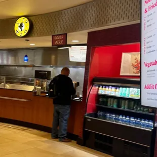 a man standing at a counter in a fast food restaurant