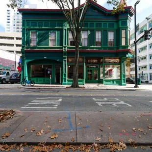 a green building on the corner of a street