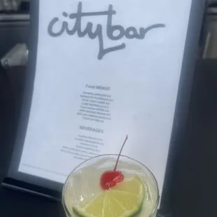 a drink in a plastic cup with a cherry on top