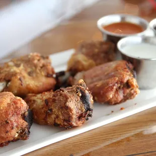a plate of fried food with dipping sauces