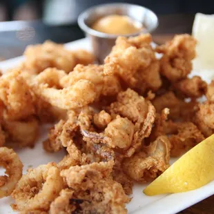 a plate of fried calamails and a wedge of lemon