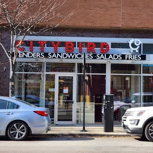 two cars parked in front of a store