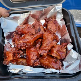 a person holding a tray of wings