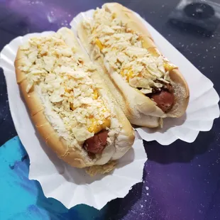 two hot dogs covered in cheese