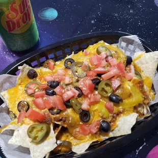 a plate of nachos and a can of soda