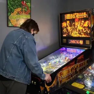 a man playing a pinball game