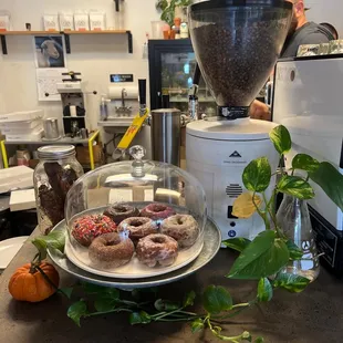 a coffee grinder and a plate of doughnuts