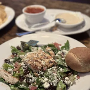 a plate of salad and a roll