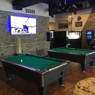 two pool tables and a television