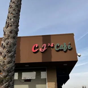 a palm tree in front of a cafe