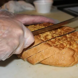 a person cutting a loaf of bread