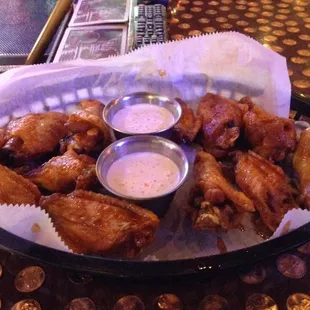 a basket of chicken wings with dipping sauce
