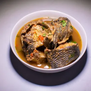 a bowl of soup with fish and vegetables