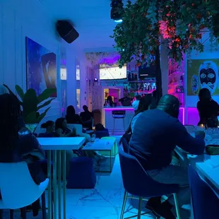 people sitting at tables in a brightly lit room