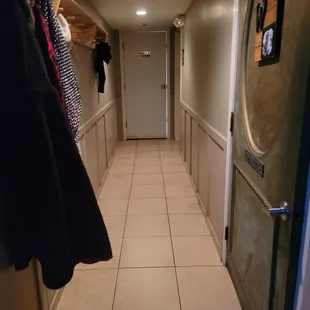 a long hallway with clothes on hangers