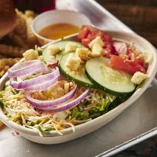 a bowl of salad and french fries