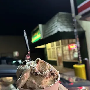 a hand holding a cup of ice cream