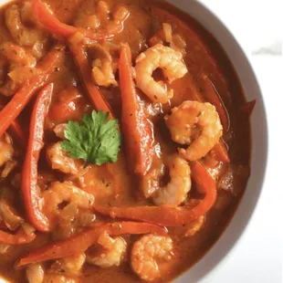 a bowl of stew with shrimp and carrots