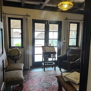 Office area with a fireplace. Doors lead out to patio.