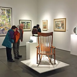 Visitors looks at a chair by Sam Maloof in the ReGeneration exhibition.