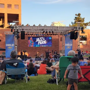 a crowd of people sitting in lawn chairs