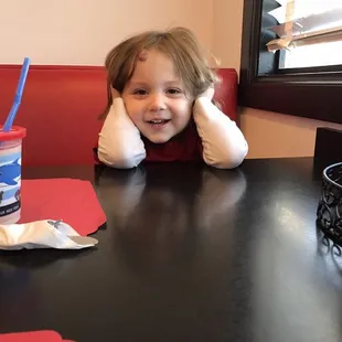 a little girl sitting at a table