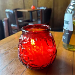 a red glass candle holder on a wooden table