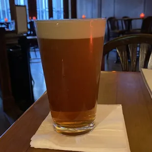 a glass of beer on a napkin