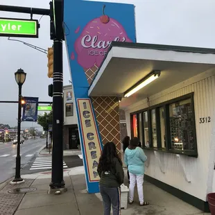two women standing outside of a store