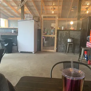 a table with a drink and a refrigerator in the background