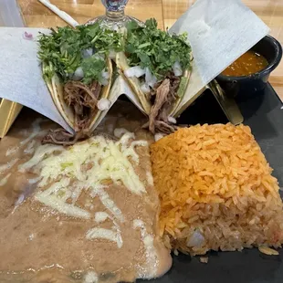 Carnitas tacos refried beans and Mexican rice and a delightful pina colada in the back!