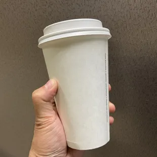 a hand holding a paper cup