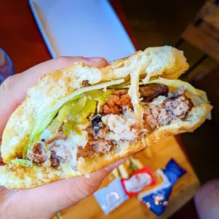 a hand holding a sandwich