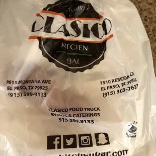 Plastic bag holds to-go meal and adverts to both locations