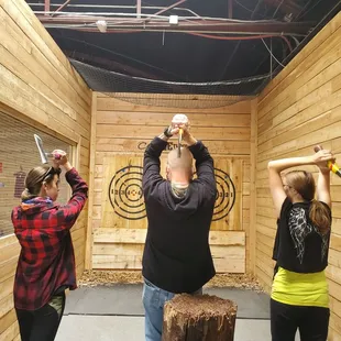 Kyle teaching the girls to throw axes.