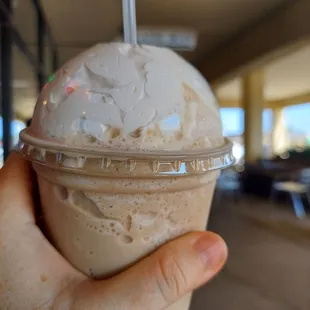 a hand holding a cup of ice cream