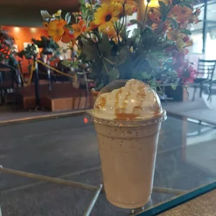 a cup of iced coffee on a glass table