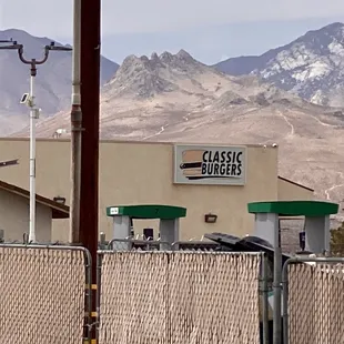 a chain link fence with mountains in the background