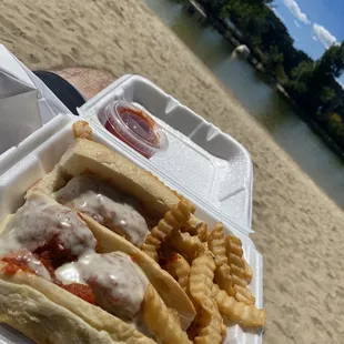 a hot dog and french fries on the beach