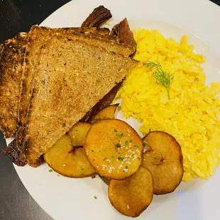 a plate of scrambled eggs, toast, and potatoes