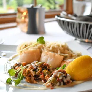 scallops and pasta on a white plate