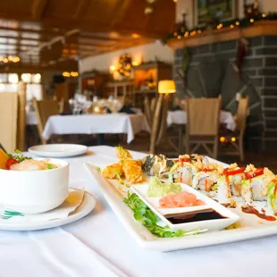 a plate of sushi and a bowl of dipping sauce
