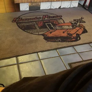 a man sitting in front of a pizza oven