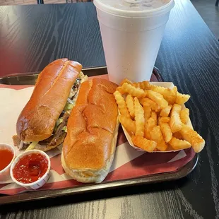Chipotle steak sandwich with fries and a drink.