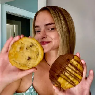a woman holding a chocolate chip cookie