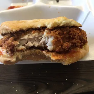 a half eaten sandwich in a styrofoam container